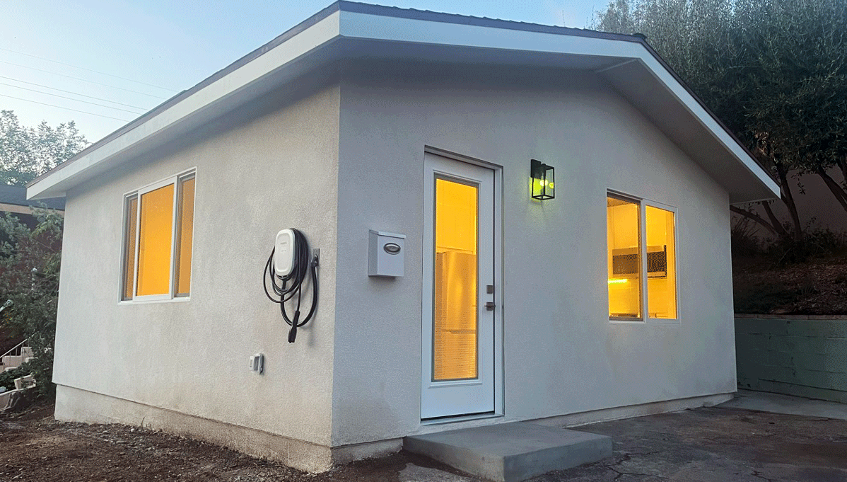 An exterior shot of Audrey the ADU, with warm light seen through the windows.